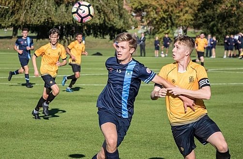 two footballer in blue and yellow fight for the ball