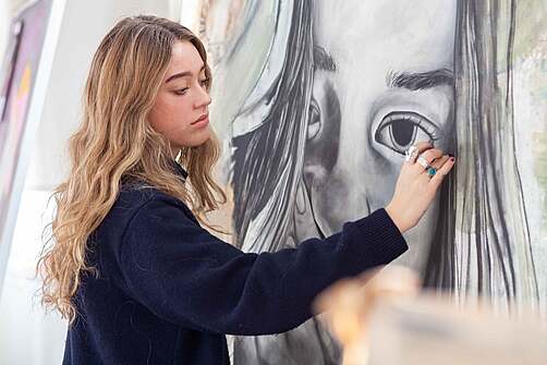 Student studying by the dorm room window with scenic view.