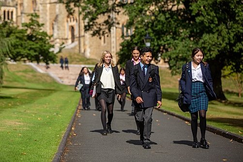 Malvern Pupils in their uniforms walking together over the school campus chatting
