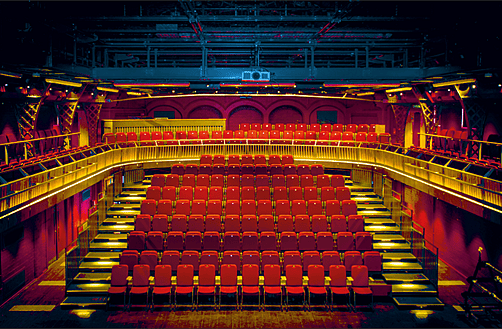 The stunning Malvern College Theatre with red seats and its upper circle