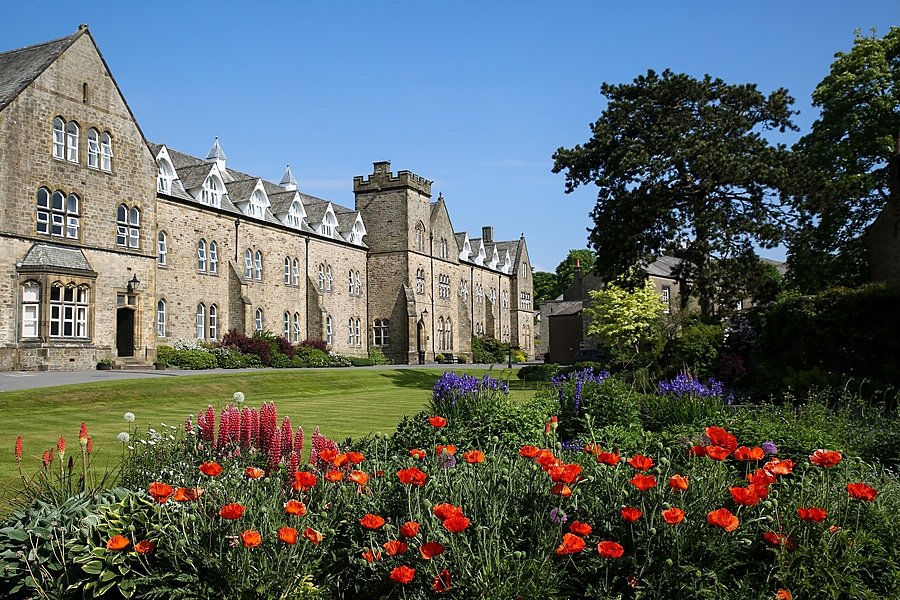 Giggleswick School surrounded by beautiful flower beds and trees on the campus