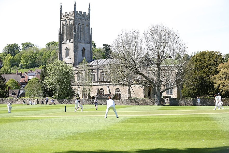 King's Bruton with cricket players on the green in front of the school