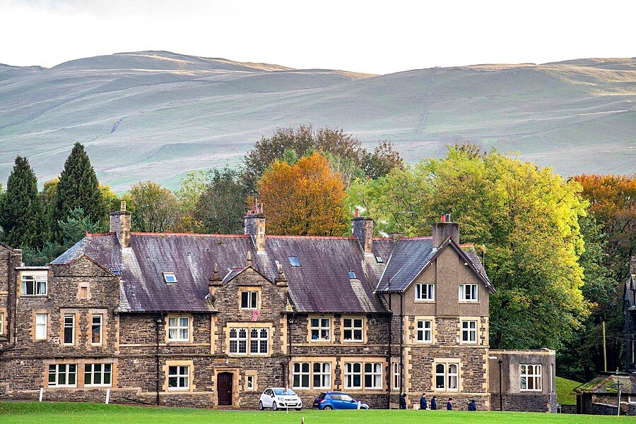 The main building of Sedbergh School in front of a mountain range