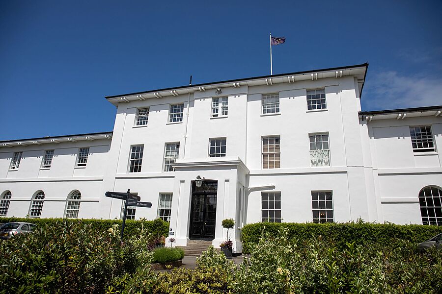 Sidcot School's white main building from the front in the sunshine