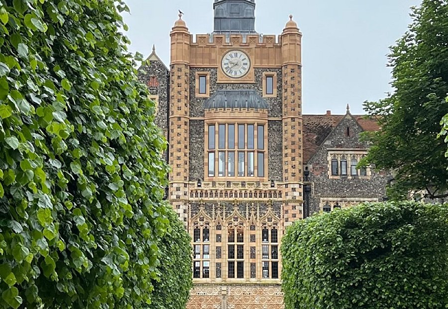 Beautiful clock tower with trees and well-maintained hedges left and right
