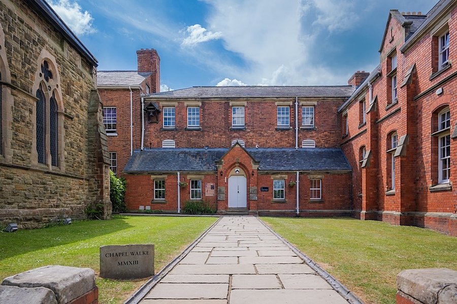 Red-brick school house next to grey-brick school chapel