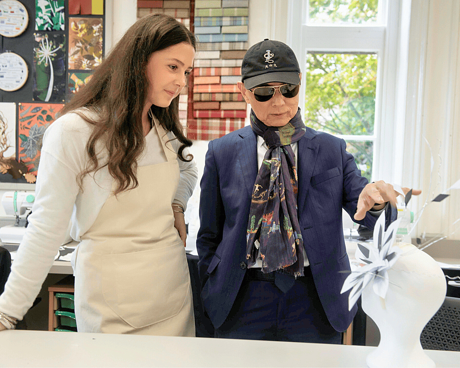 Professor Jimmy Choo working with a pupil during a fashion workshop at Monmouth
