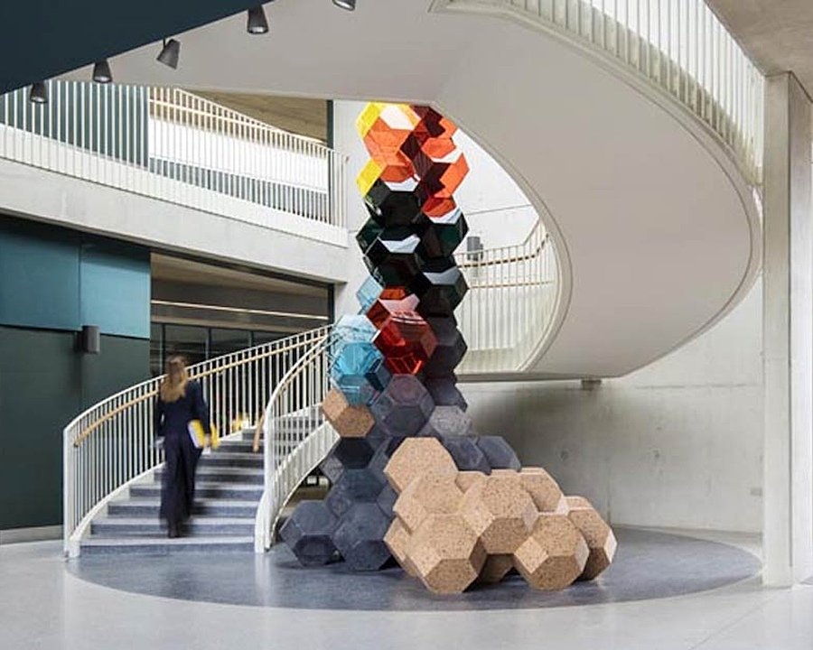 an impressive contemporary sculptural art piece displayed inside a spiral open staircase