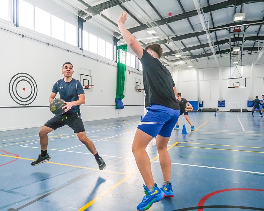 Students playing basketball in indoor gym
