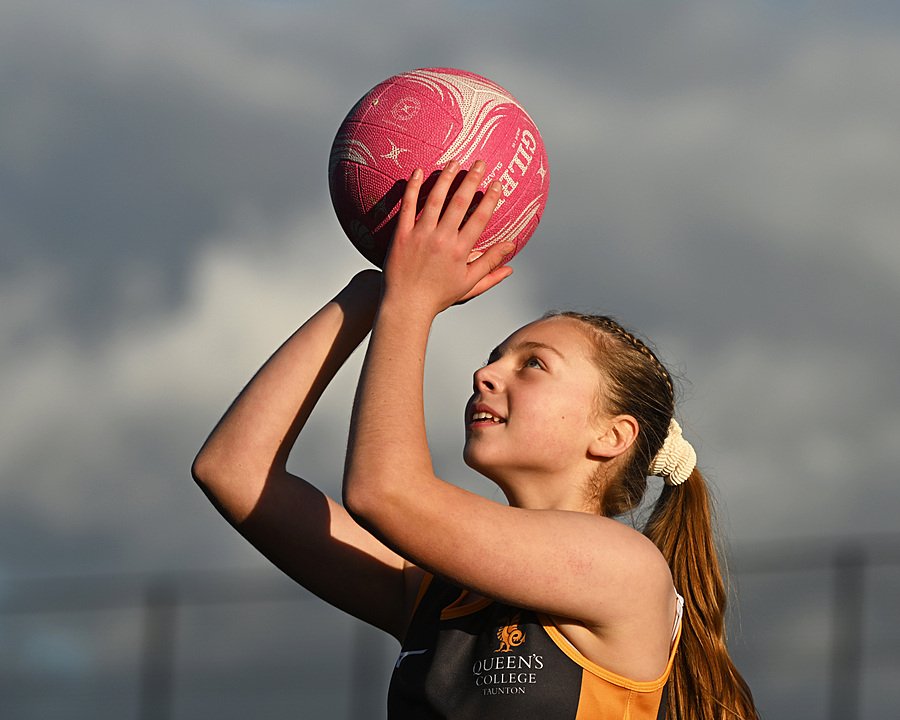 Female boarding school student playing netball during sports training