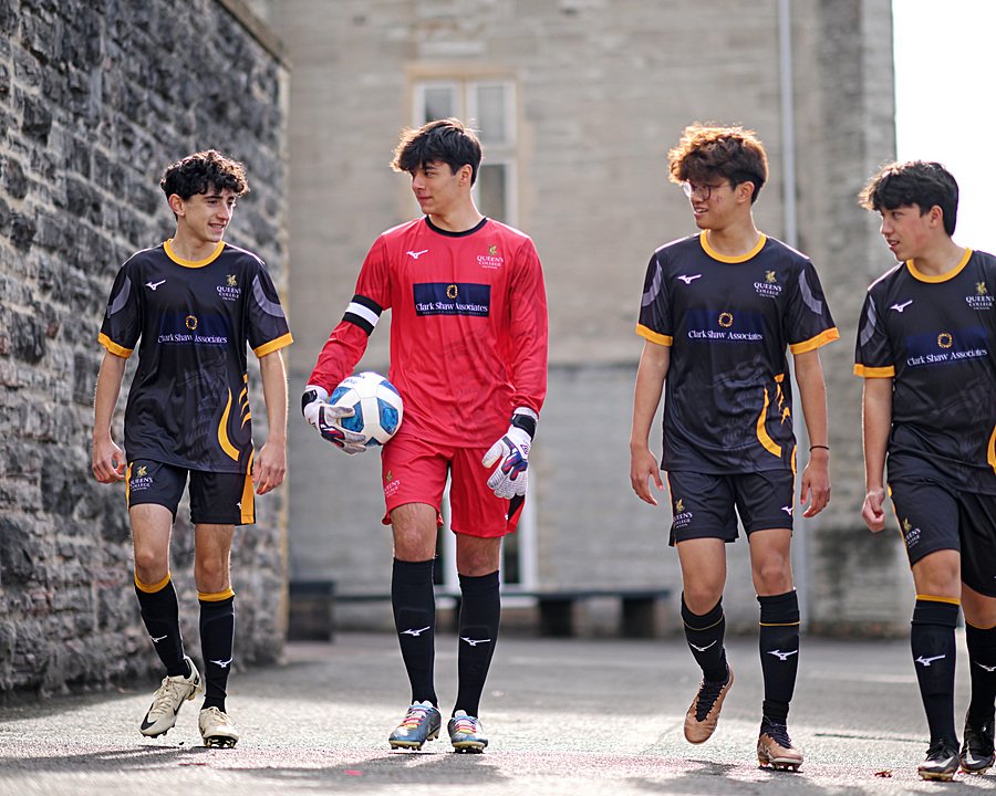 Boarding school football team walking across campus in sports kit