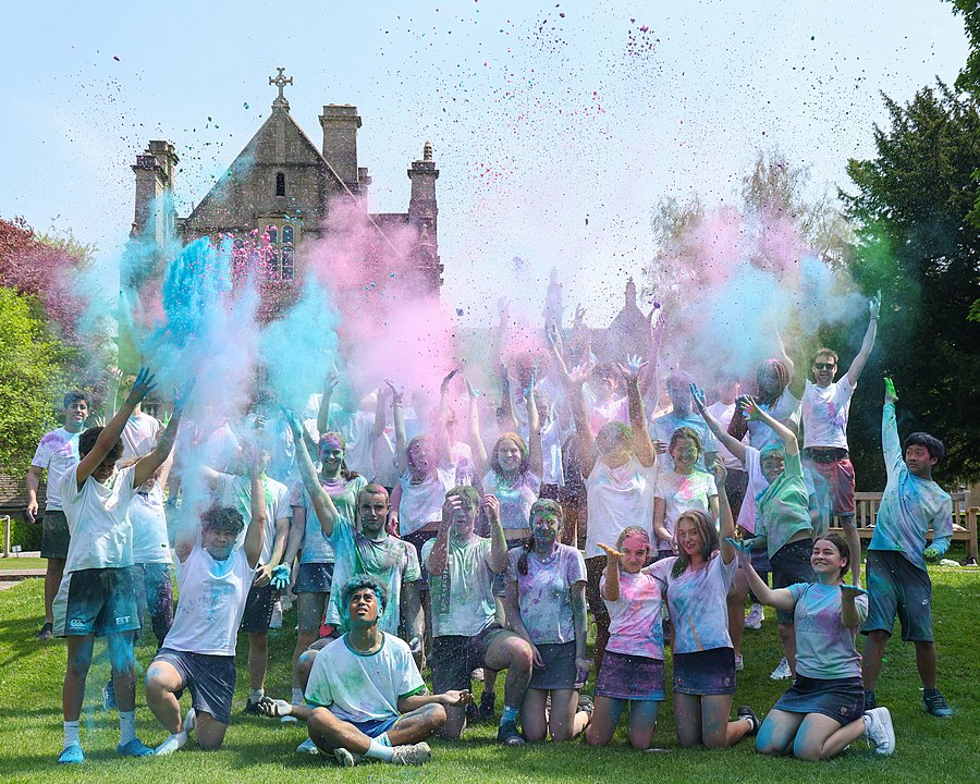 Students in white t-shirts throwing colors into the air for a color run