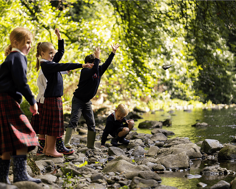 Boys and girls play by a stream in good weather