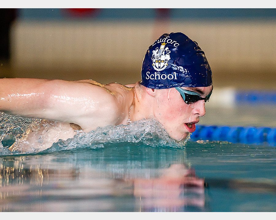 A student performing dolphin strokes in the swimming pool at Culford School