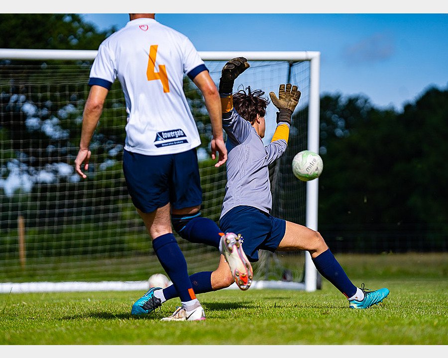 A student scoring a goal during football training at Culford School