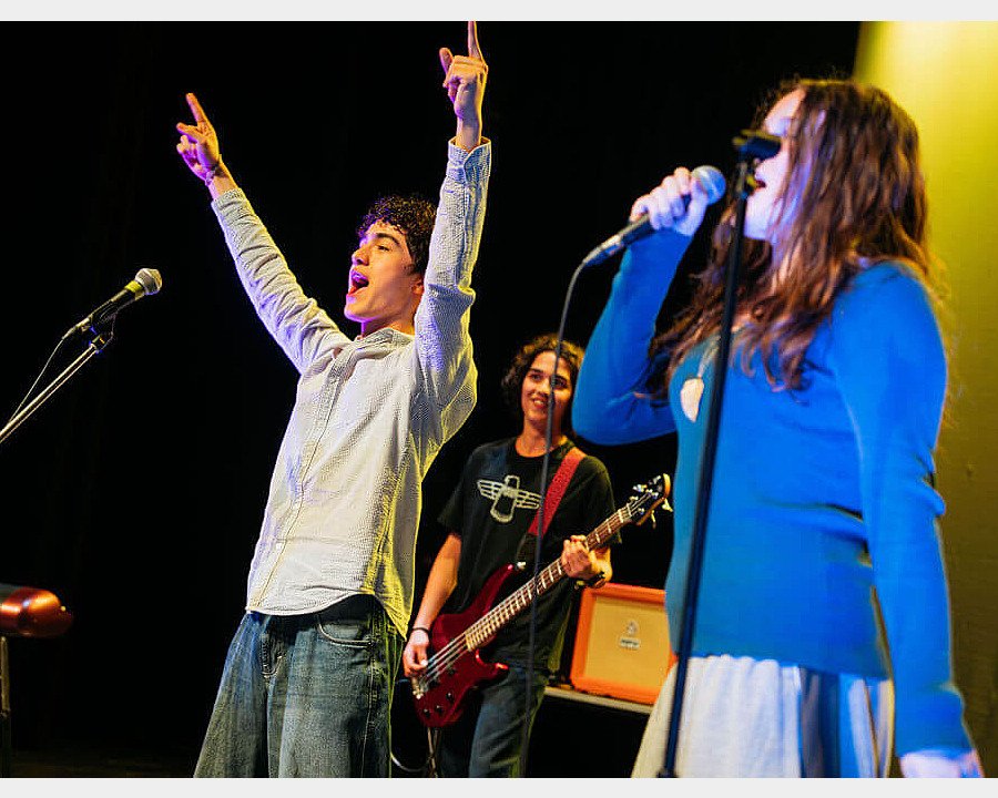 Students performing music together on stage at Charterhouse School