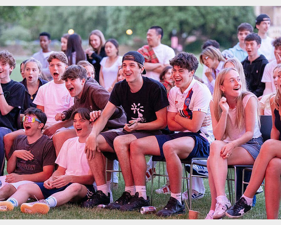 an audience of Charterhouse students is laughing and enjoying a piece of entertainment