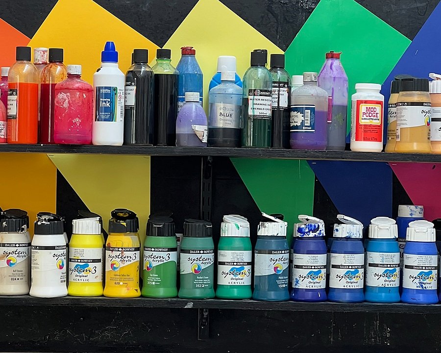 Bottles with paint in all colours of the rainbow on the shelves of the Dean Close Art Department