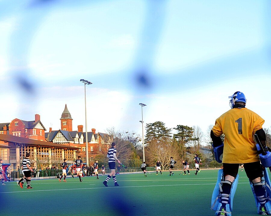 Students at Dean close playing hockey on astro turf
