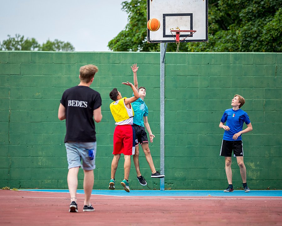Boys playing basketball as part of Bede's Summer School on the Lancing campus