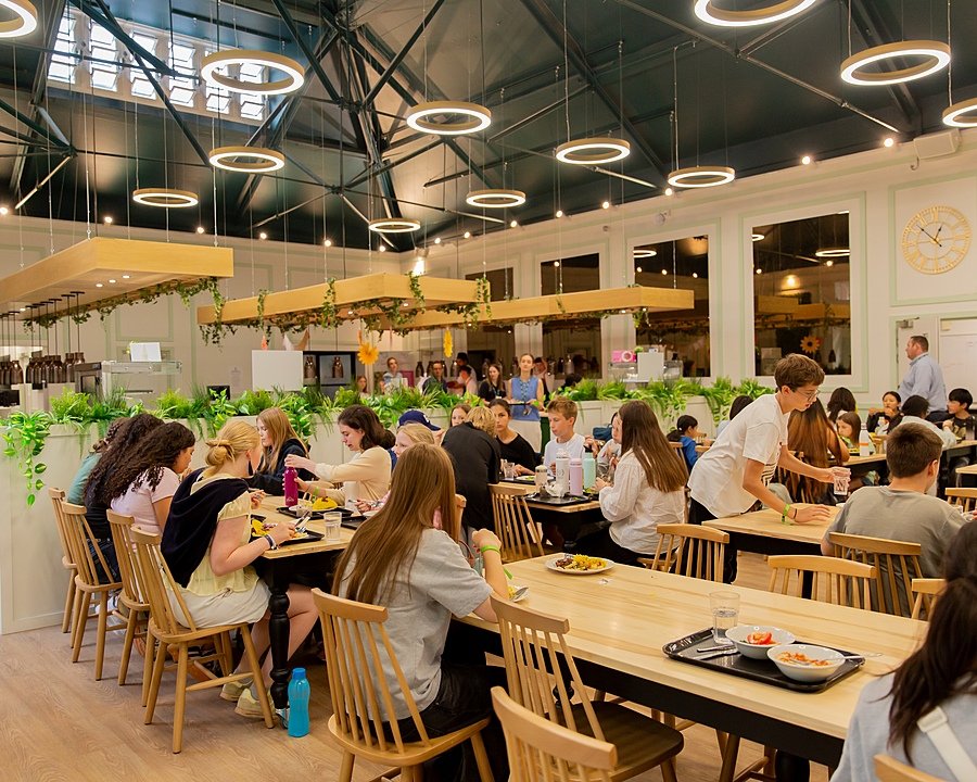 Summer School students sitting and eating at the Dining Hall at Malvern College