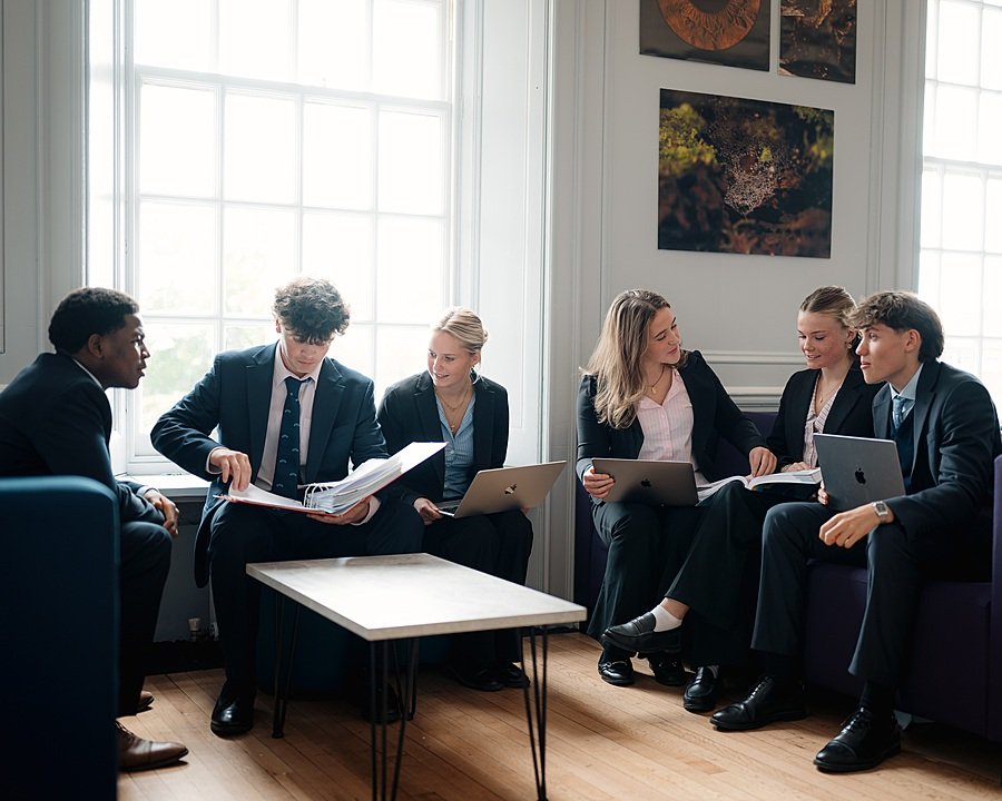 Group of students sitting and talking in a classroom at Pangbourne College