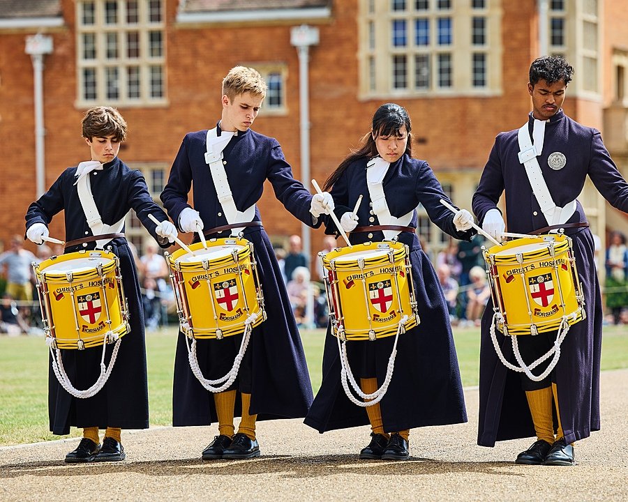Four Royal Hospital students in their uniforms playing the drums in the school's very own marching band