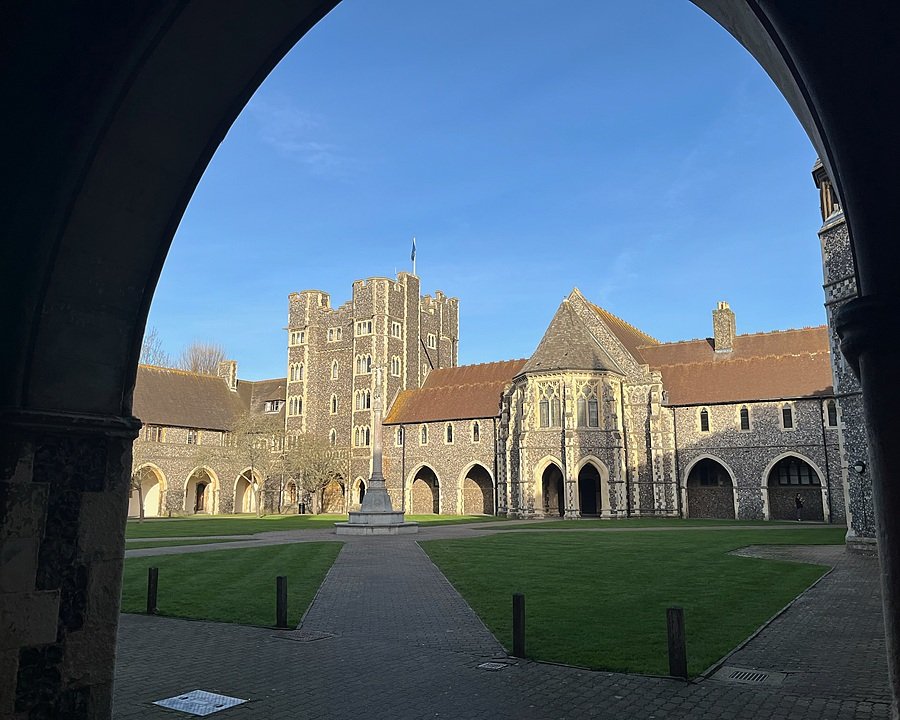 Stone courtyard framed by arched walkways and medieval-style school buildings.