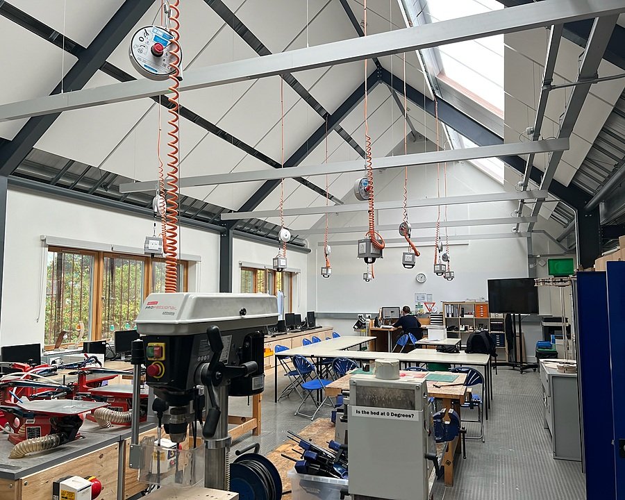 Modern design and technology workshop with high ceilings, workbenches, and machinery, where students can build and create projects.