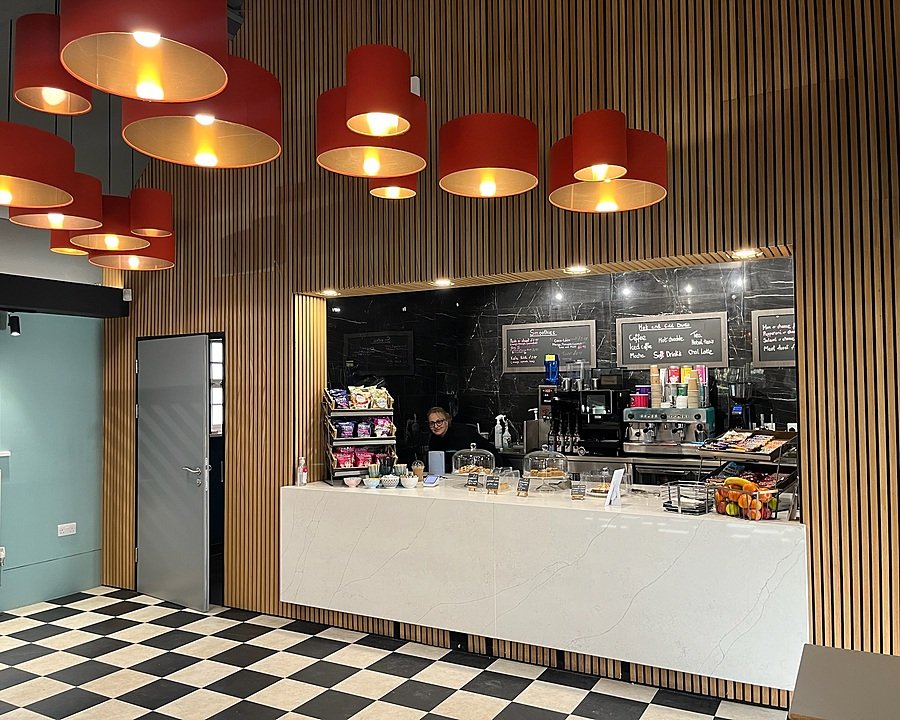 Interior of a school café with red and gold lampshades and counter