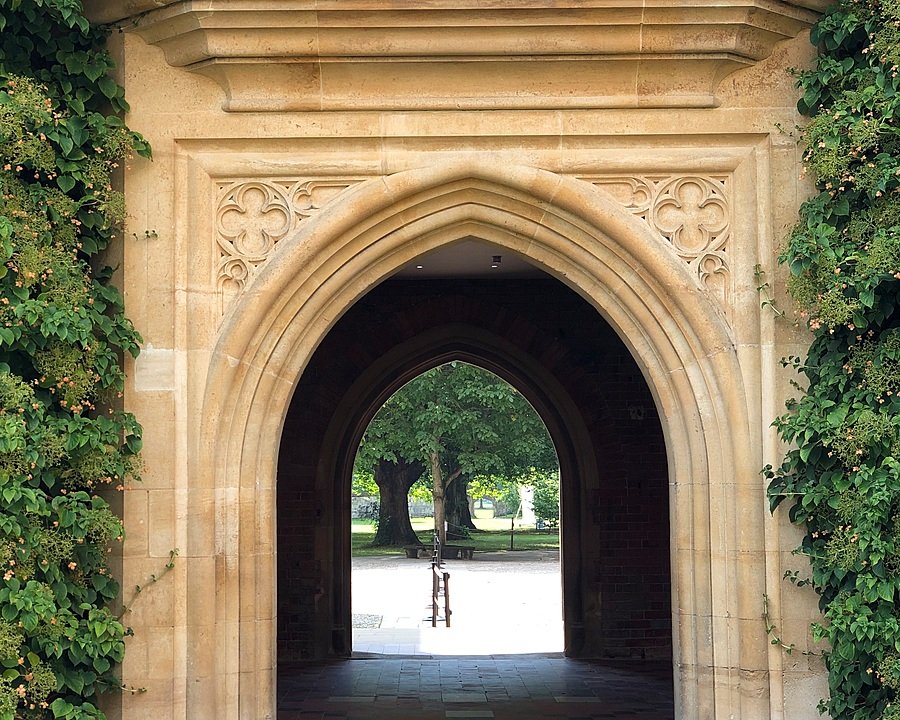 Old gate in yellow brick with garden at the end