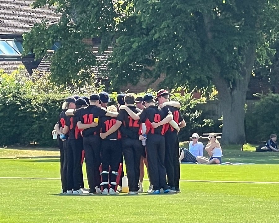 Cricket players on a field in a huddle