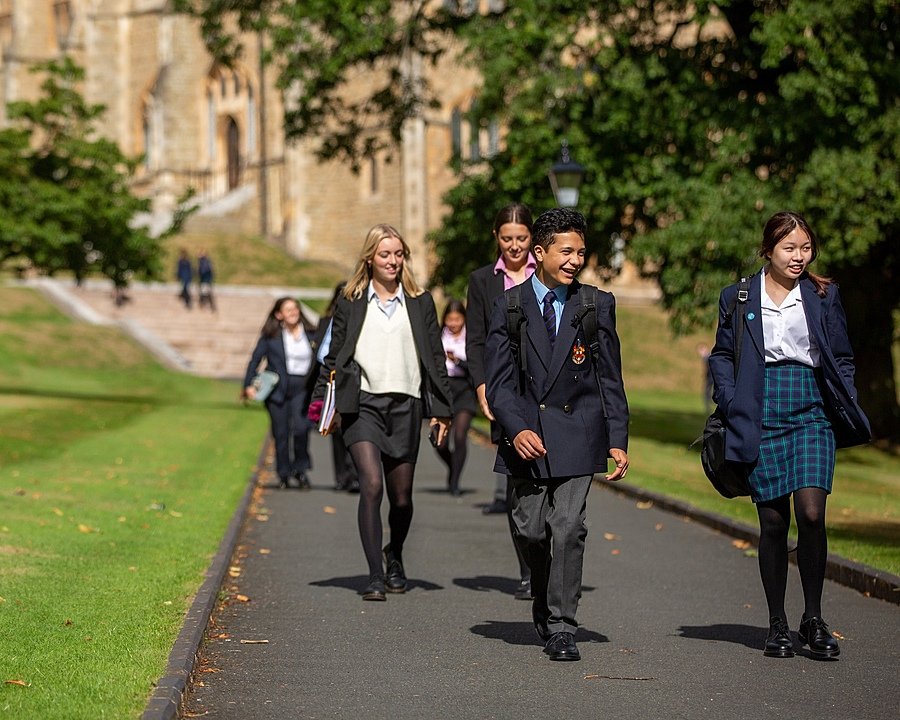 Malvern Pupils in their uniforms walking together over the school campus chatting