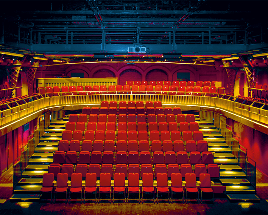 The stunning Malvern College Theatre with red seats and its upper circle