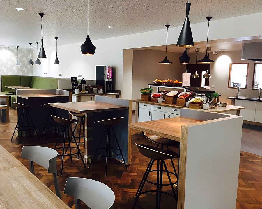 A spacious room with modern furniture, a salad bar and tables for pupils to eat