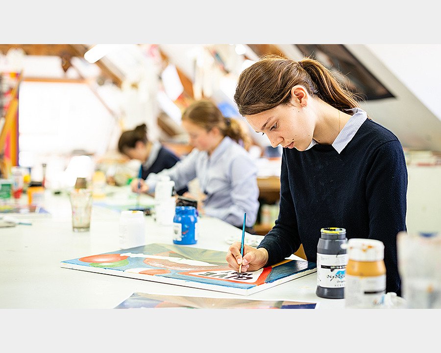 Students doing paintings in their school's bright art department