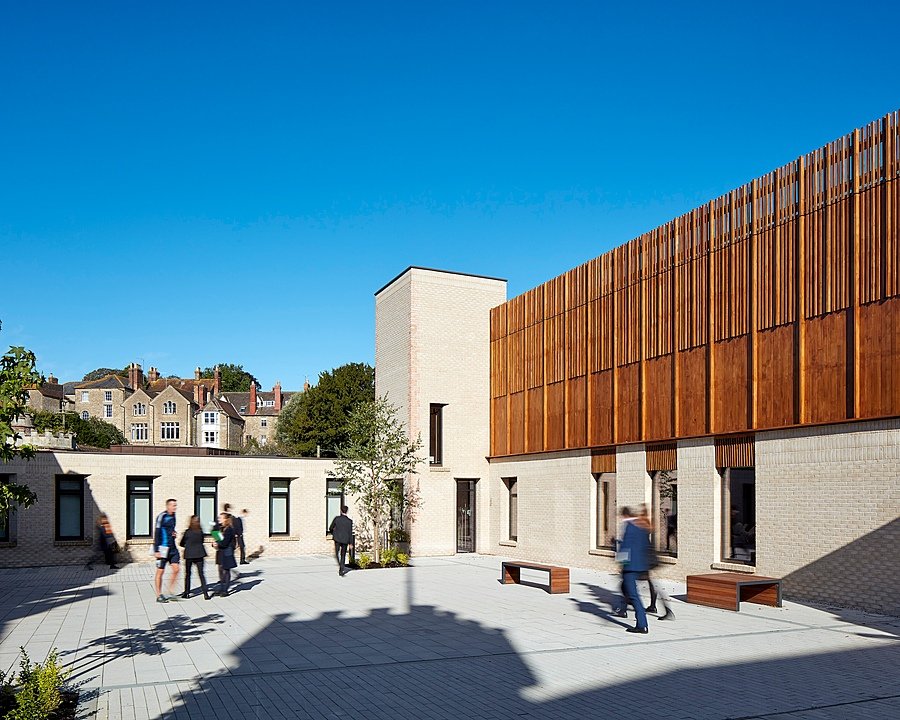 School campus on a sunny day with music building and rushing pupils