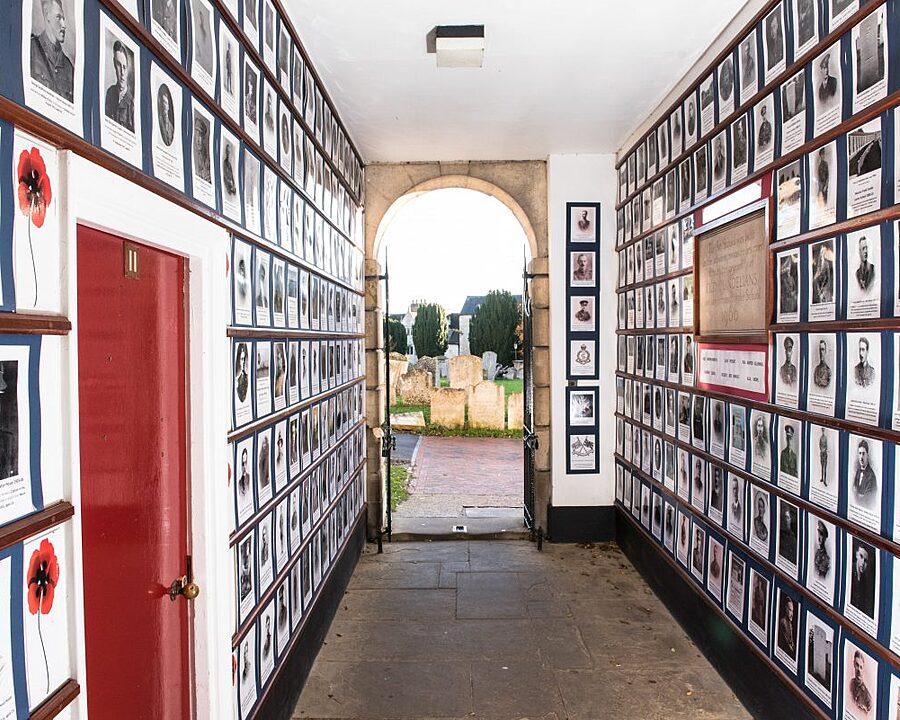 The walls of a hallway entirely covered from top to bottom with picture frames