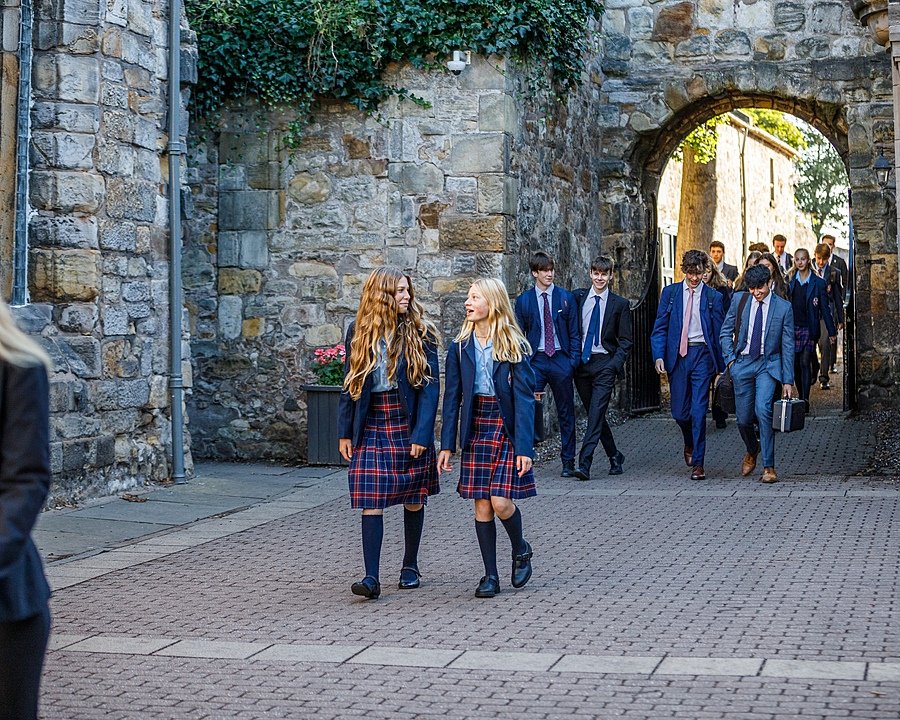 Male and female students in their school uniforms on their way over the school campus