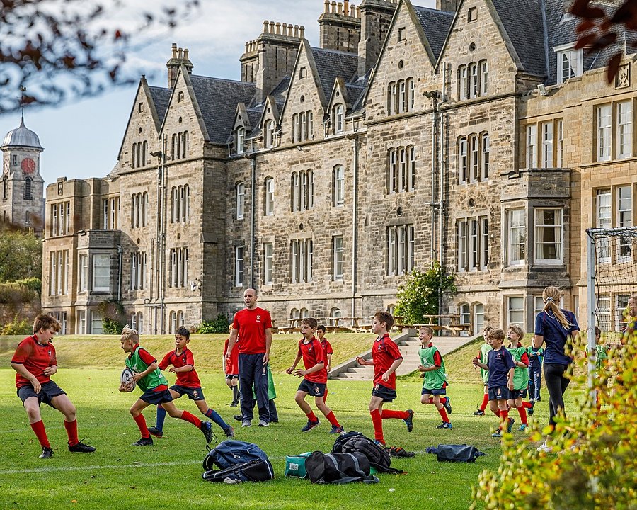 Pupils in their red school jerseys are playing rugby outside their school