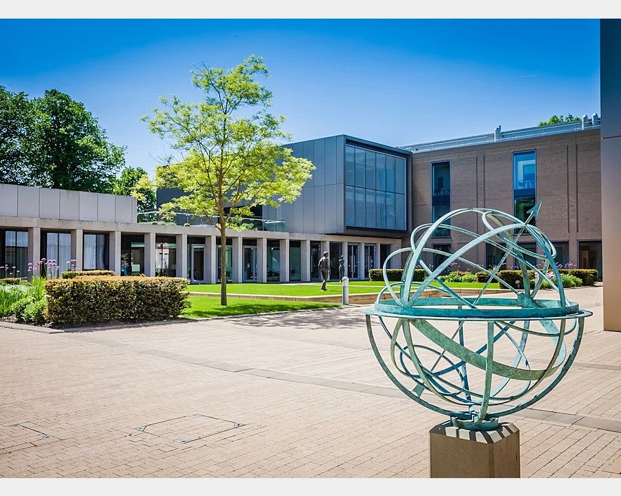 A sun clock infront of modern school buildings