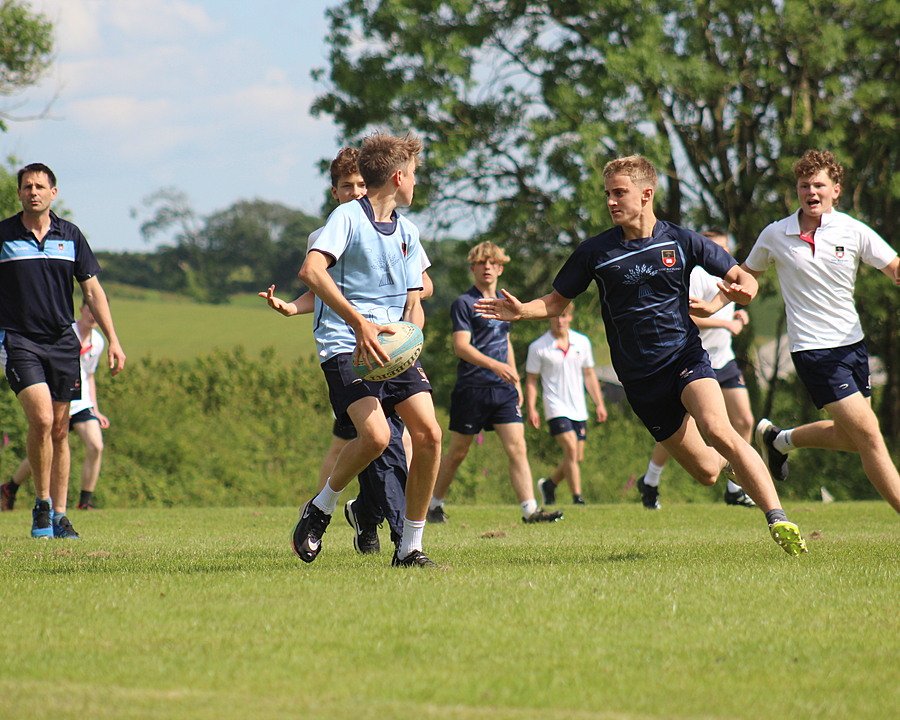 Boys in the middle of a rugby game, running