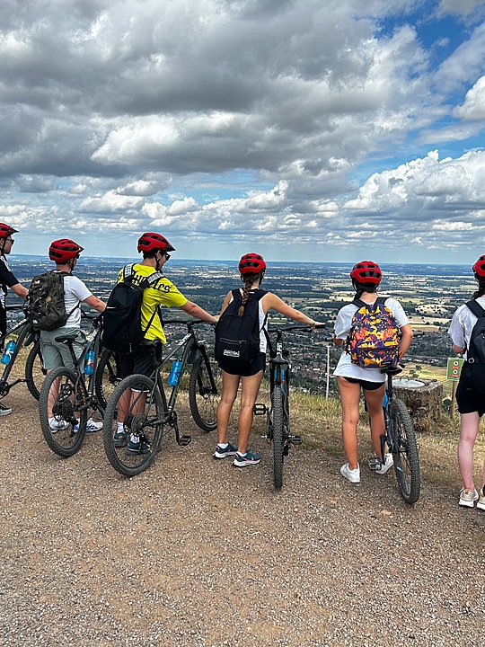 Six Summer school students enjoying a stunning view into the countryside on their Mountain Biking trip