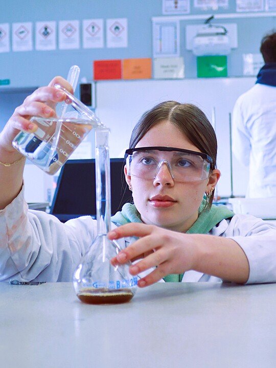 Student carrying out a science experiment in a modern laboratory.