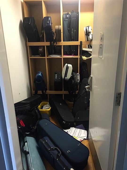 an instrument room with lots of instrument cases stored away and on the floor