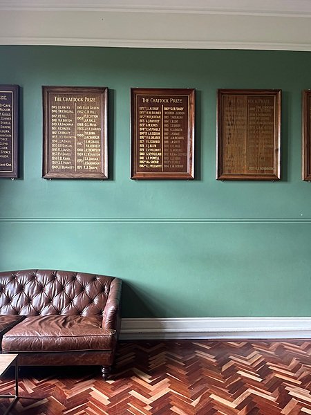 A chesterfield sofa in front of the long list of prizes in one of the boarding houses at Bromsgrove School