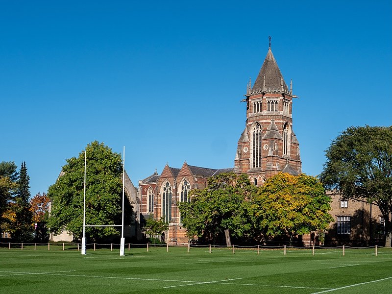 Rugby School with its impressive tower and a rugby pitch in the foreground
