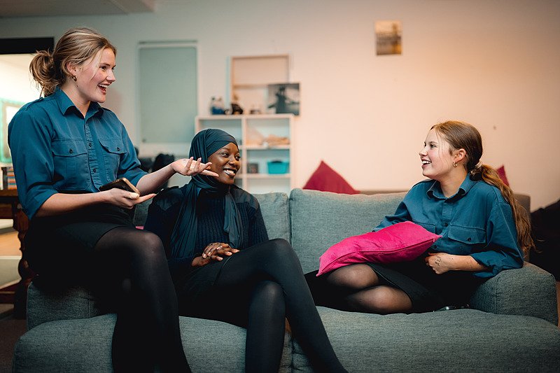 Girls students sitting on sofas in a common room at Pangbourne College