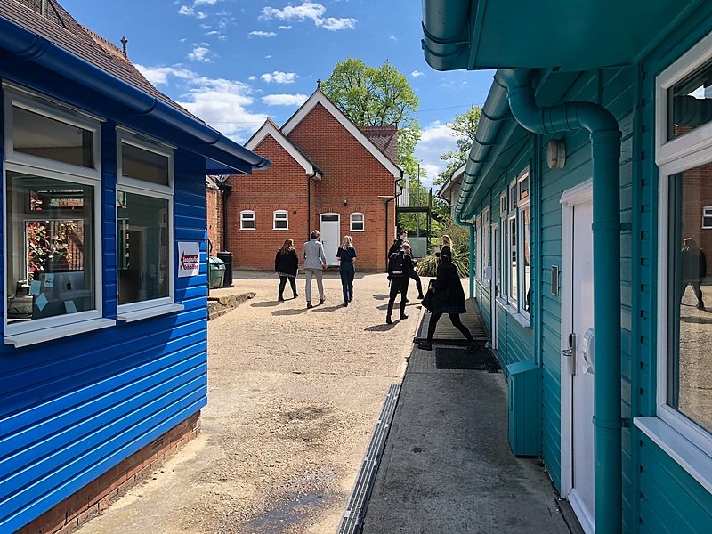 Pupils walking amongst colourful study houses at Bede's School