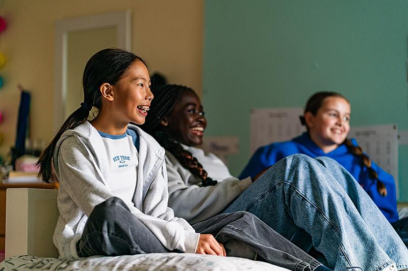 three laughing female students in their own clothes